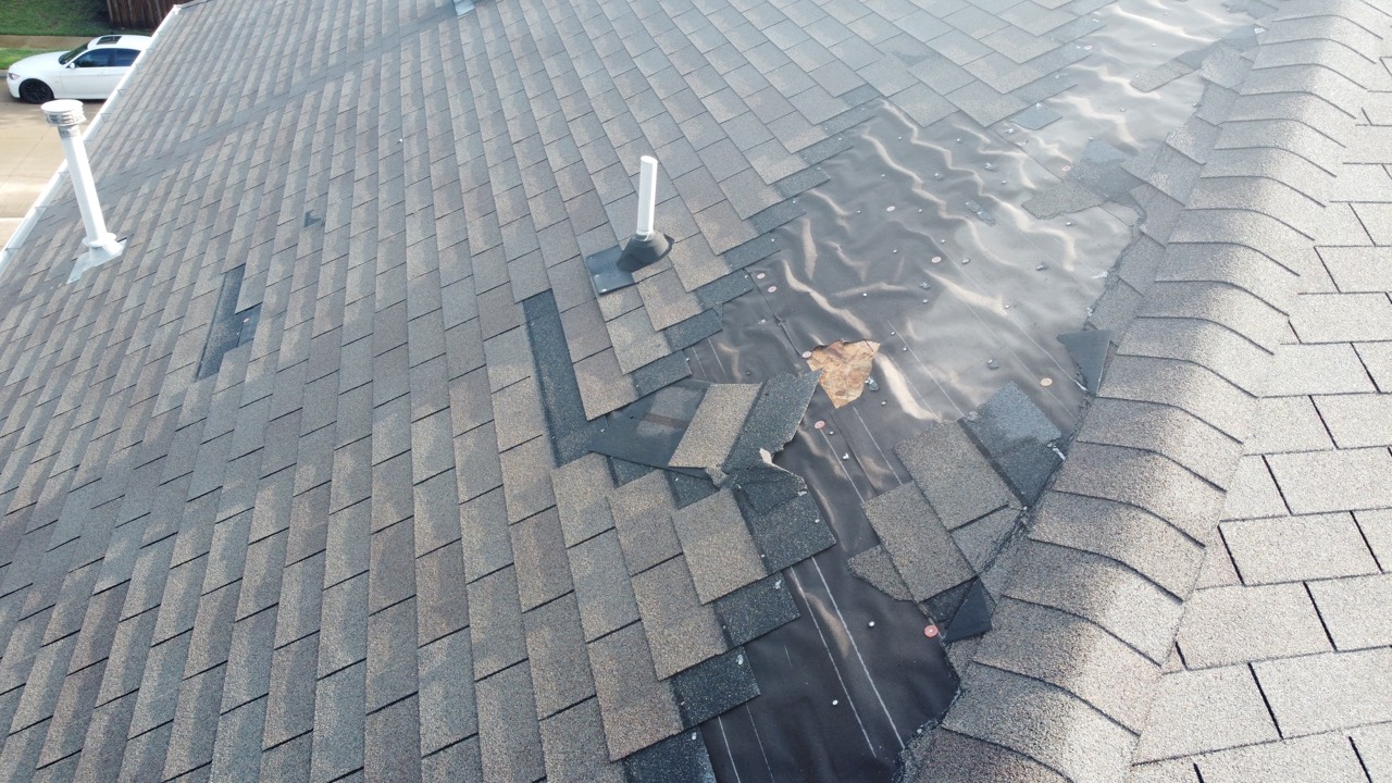 Storm-lifted shingles exposing the roof deck